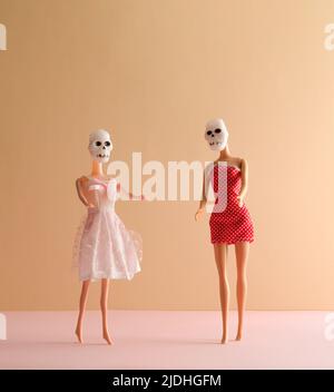 Halloween funny concept made of girl dolls with skull costume. Minimal holiday concept. Stock Photo