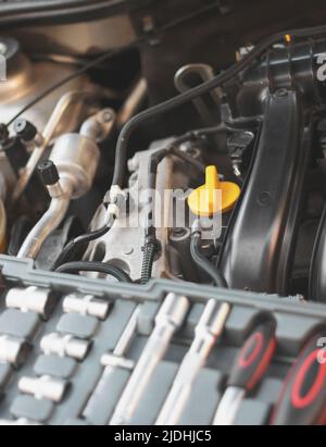 A set of socket wrenches lies on the car engine in the engine ...