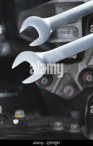 Wrenches for repairs lie on the car engine in the engine compartment. Stock Photo