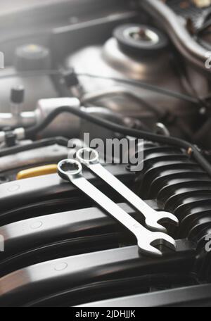 Wrenches for repairs lie on the car engine in the engine compartment. Stock Photo