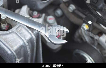 The repair wrench lies on the car engine in the engine compartment. Stock Photo