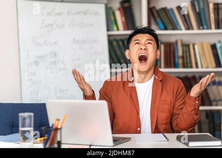 Japanese Teacher Man Shouting Having Professional Burnout Sitting In Classroom Stock Photo