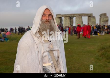 WILTSHIRE, ENGLAND - JUNE 21.2022: Druids, pagans and revellers gather at Stonehenge, hoping to see the sun rise, as they take part in the Summer Solstice celebrations at the ancient neolithic monument of Stonehenge near Salisbury on June 21st 2022 in Wiltshire, England. Several thousand people gathered at sunrise at the famous historic stone circle, a UNESCO listed ancient monument, to celebrate the solstice Stock Photo