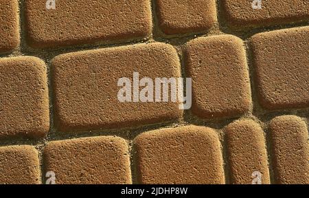 Yellow brown brick road.Cobblestones on the pavement close-up Stock Photo