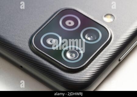 four smartphone lenses on the body close-up Stock Photo