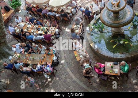 People dining outdoors around a large public fountain, Seillans, France Stock Photo