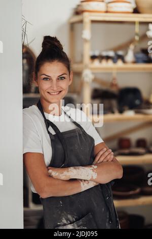 Beautiful Female Entrepreneur in Her Clay Studio, Woman Happy Owner of a Small Pottery Business Stock Photo