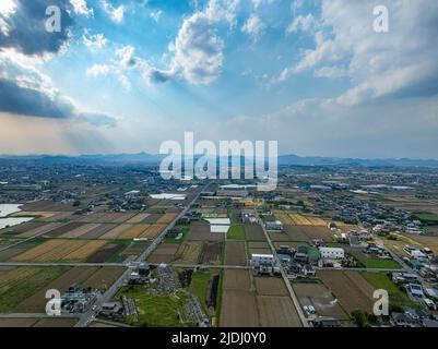 Dramatic clouds and sun rays shine over rural farming area Stock Photo