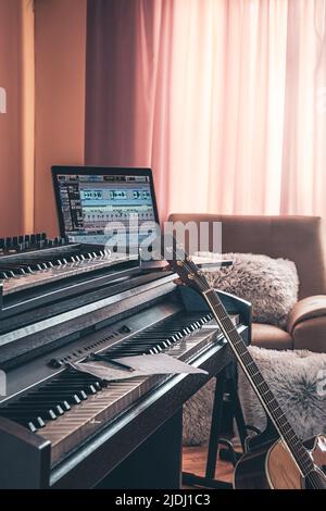 Electronic piano and guitar in room interior. Stock Photo