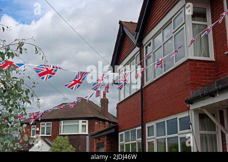 English patriotism in Grappenhall village, Kings coronation and national events - Union flags and bunting flying across suburban St, Warrington, UK Stock Photo