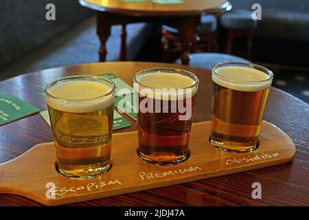 British real ale in thirds - Beer paddle with a full pint of beers, served as a third each, with names, Appleton Thorn Village Hall, Warrington, UK Stock Photo