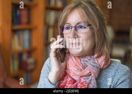 White woman talking on the phone happy to receive good news. Stock Photo