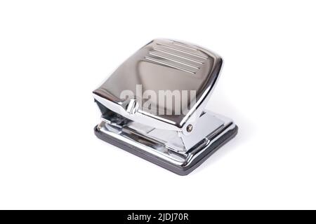 Manual metal machine for making holes in paper on a white isolated background. Stock Photo