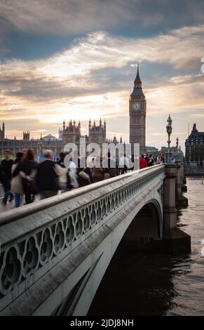 Commuter rush hour, Big Ben, London. Office workers making their way across Westminster Bridge with the iconic London landmark in the distance. Stock Photo