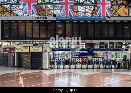 London, UK. 21st June, 2022. Victoria station is empty on the first day of the National Rail strike. The information boards are empty and a few people wander the station, despite announcements that the last trains have gone at 6.15 and the station is soon to close. Credit: Guy Bell/Alamy Live News Stock Photo