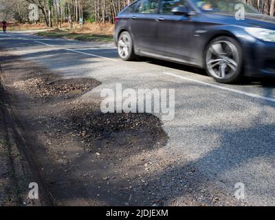 Potholes on a road in The New Forest, Hampshire, UK Stock Photo