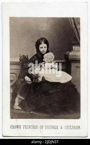 Full length portrait of Crown Princess Victoria and her children, July 1861. From left to right, Prince Wilhelm (1859 - 1941), Victoria, Crown Princess of Prussia (1840 - 1901) and Princess Charlotte (1860 - 1919) (on lap). Photography by John Jabez Edwin Mayall (1813 - 1901). Stock Photo