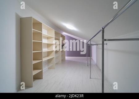 Large empty white room closet for clothes and things in attic of residential building. Stock Photo