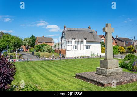 War Memorial and thatched cottage on The Green, High Street, Chalgrove, Oxfordshire, England, United Kingdom Stock Photo