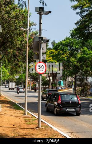 A speed trap radar with a 50 km speed limit regulatory sign right below checking the speed of passing traffic at Paulo VI avenue in a normal day. Stock Photo