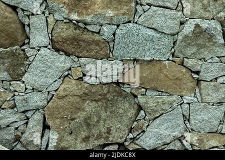 Stone wall for background or backdrop uneven cracked real stone wall Stock Photo