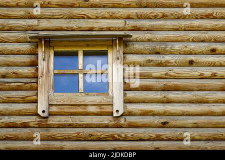 Background in the form of a fragment of an authentic wooden house in the form of a window with a wooden frame. Stock Photo