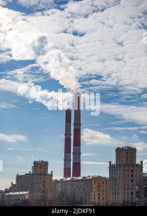 CHP in the city. Smoke rises into the sky from the heat pipes  Stock Photo