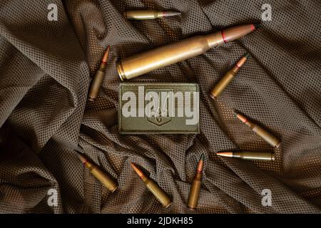 Pili lie on a green background and next to it lies a stripe with the flag of Ukraine, the war in Ukraine, ammunition Stock Photo