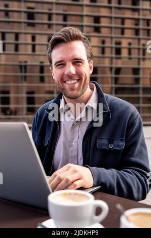 smiling businessman working on a terrace Stock Photo