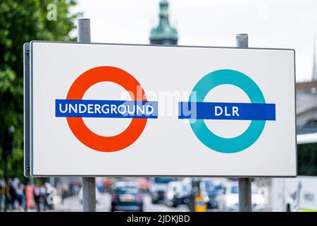 London, UK. 11th June 2022. Sign for the Underground and DLR tube station located at Tower Hill, London, set against a busy road with traffic. Stock Photo