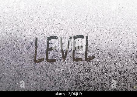 level word written on a window with raindrops Stock Photo