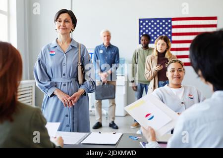 Front view portrait of diverse people standing in line on voting day in ...