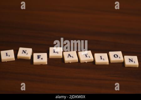 Selective focused close up shot of Inflation word. Made by using the letters in blocks in a wooden background. Stock Photo