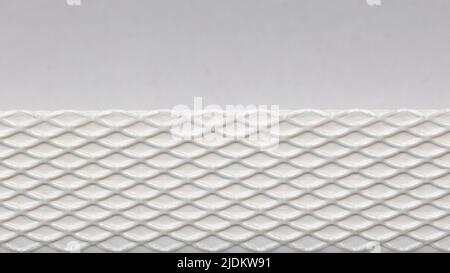 White cardboard or paper texture with patterned strip of plastic. Horizontal rough textured empty background Stock Photo