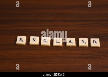 Selective focused close up shot of England word. Made by using the letters in blocks in a wooden background. Stock Photo