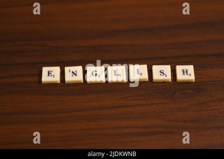 Selective focused close up shot of English word. Made by using the letters in blocks in a wooden background. Stock Photo