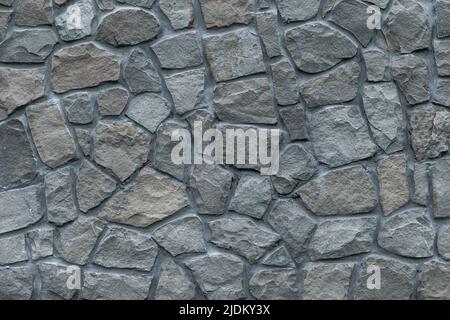 Gray stone wall background, great design for any purposes. Natural stonewall. Grunge rock texture. Grey floor surface. Cobblestones backdrop. Building Stock Photo