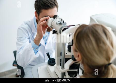 Optometrist checks the patient's intraocular pressure in optician's shop or ophthalmology clinic Stock Photo