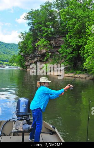 West Virginia's beautiful Kanawha Falls (New River) offer great fishing for a variety of species. An angler casts for smallmouth bass. Stock Photo