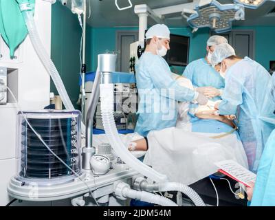 Moscow. Russia. October 18, 2021. Artificial lung ventilation apparatus and medical devices in the operating room. Selective focus. A team of surgeons operate on a patient on an operating table. Stock Photo