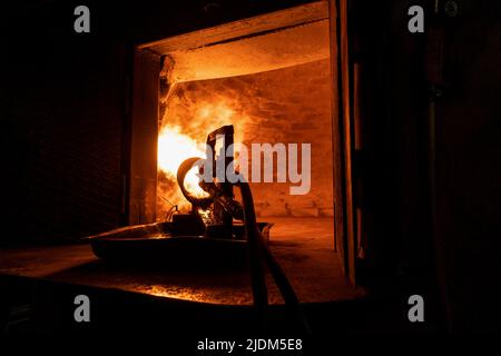 Close-up of a fire cannon warms up a brick oven with a huge flame for further baking in it. Stock Photo