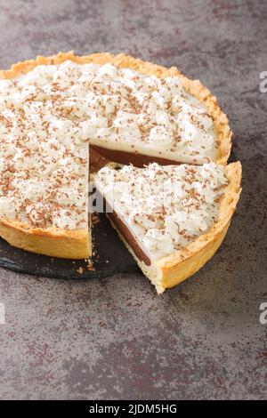 Coconut Hawaiian dessert Chocolate Haupia Pie on a plate on the table. Vertical Stock Photo