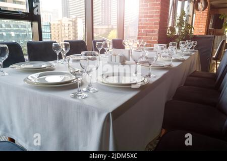 Table set with empty glasses, white plates in a restaurant Stock Photo