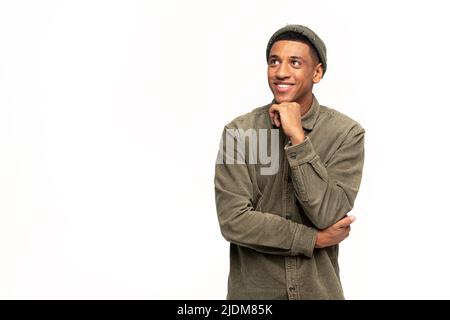 Portrait of happy satisfied handsome young man in shirt standing with crossed arms and looking away with toothy smile. Indoor studio shot on white background Stock Photo