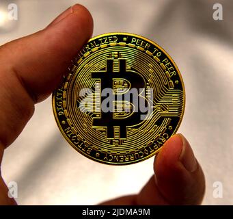 Magnifying glass over bitcoin, cryptocurrency physical coin on