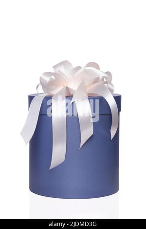 Blue round box with a white bow on an isolated white background. Stock Photo