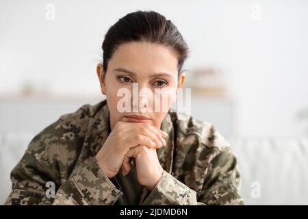 Depression In Military. Closeup Shot Of Thoughtful Female Soldier In Uniform Stock Photo