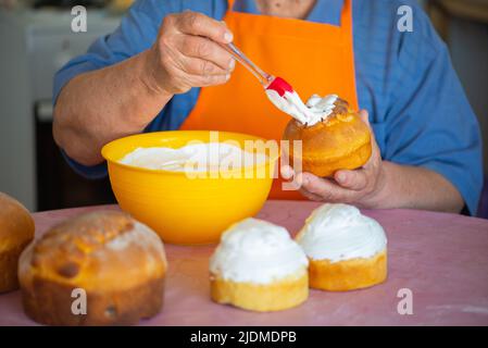 one grandmother smears Easter cake with protein cream Stock Photo