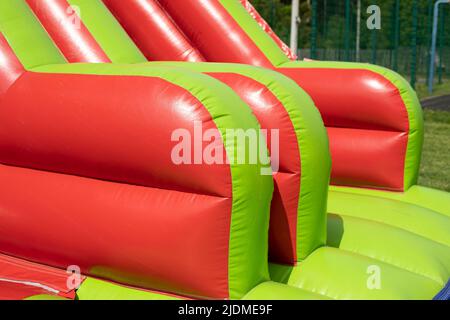 Red inflatable design. Inflatable slide. Obstacle course in amusement park. Stock Photo