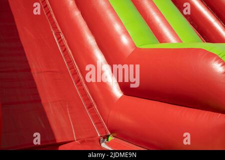 Red inflatable design. Inflatable slide. Obstacle course in amusement park. Stock Photo